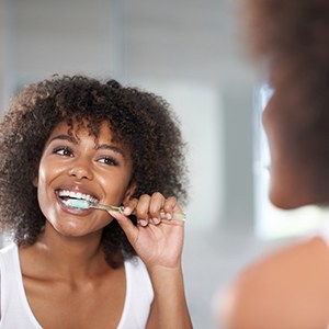 Woman smiling at reflection in dentist office